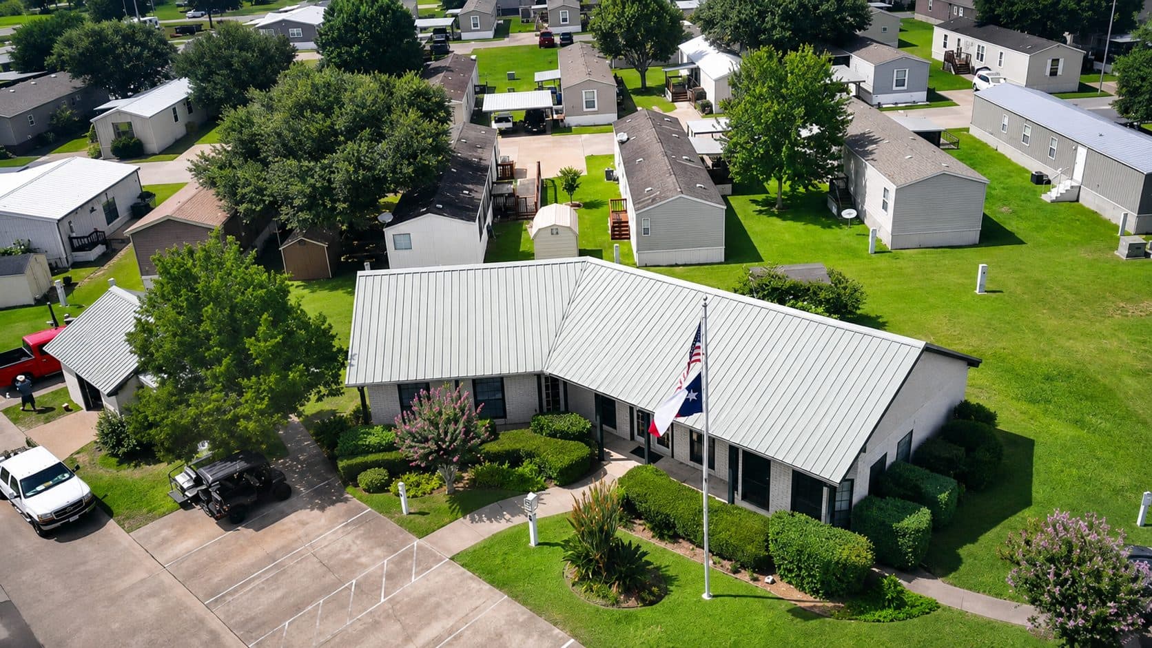 Aerial view of the Briarwood Estates clubhouse and flagpole, surrounded by homes and green lawns