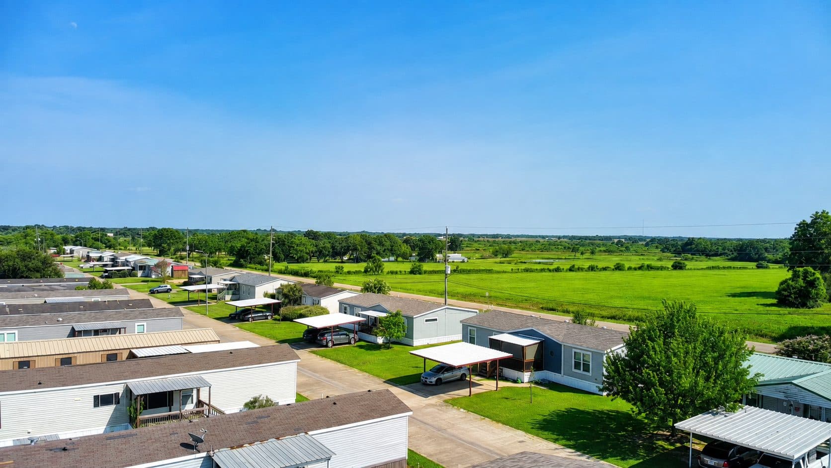 Rows of homes along a Briarwood Estates street, with green fields in the distance