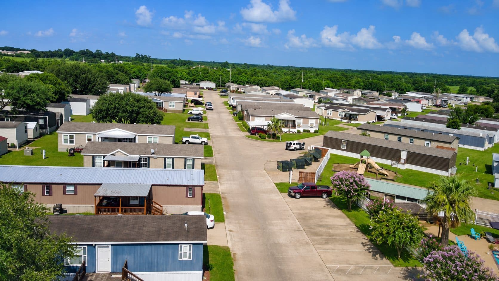 Looking down a Briarwood Estates street lined with homes, with the playground on the right